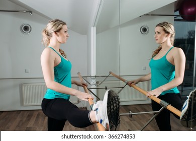 Woman Doing Stretching Near Barre In Fitness Center