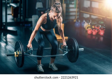 Woman doing trap bar deadlift in the gym.