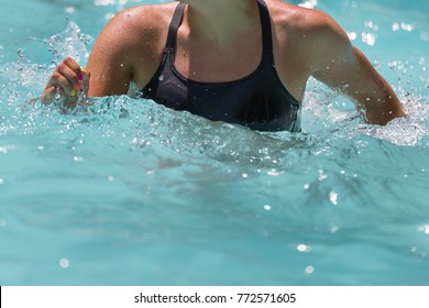 Woman Doing Water Aerobics in an Outdoor Swimming Pool.