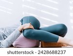 Woman doing yin yoga passive supine twists with bolster and cork block