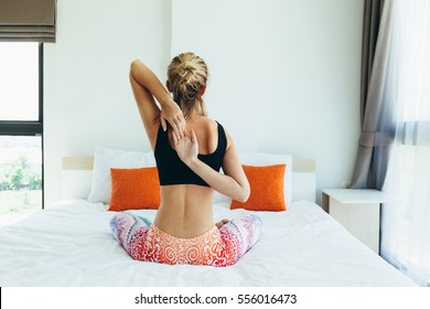 Woman Doing Yoga Exercise On Bed At Home. Morning Workout In Bedroom. Healthy And Sport Lifestyle.