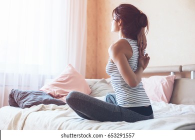 Woman Doing Yoga Exercise On Bed At Home. Morning Workout In Bedroom. Healthy And Sport Lifestyle.