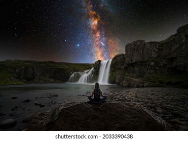 Woman doing yoga in front of a magic waterfall