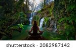Woman doing yoga in front of a  waterfall