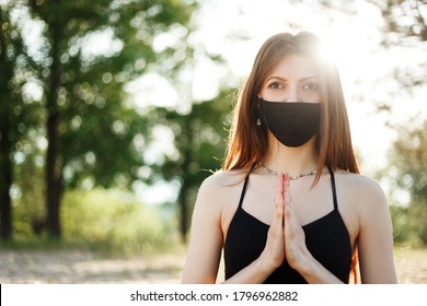 Woman doing yoga on the beach wearing a mask - Powered by Shutterstock