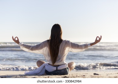 Woman Doing Yoga On The Beach 