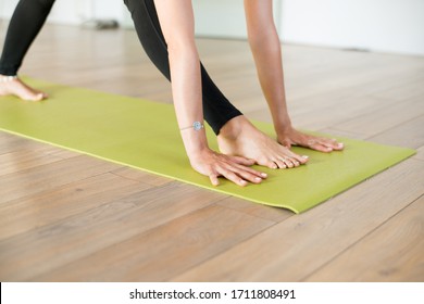 Woman Doing Yoga On The Green Mat Hands And Feet Close Up Warm Color