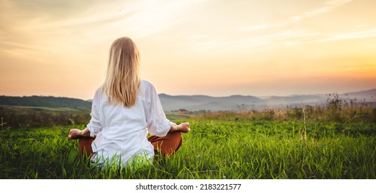 Woman doing yoga on the green grass at the mountain. Carpathians - Powered by Shutterstock