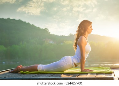 Woman doing yoga on the lake - relaxing in nature - Shutterstock ID 324427700