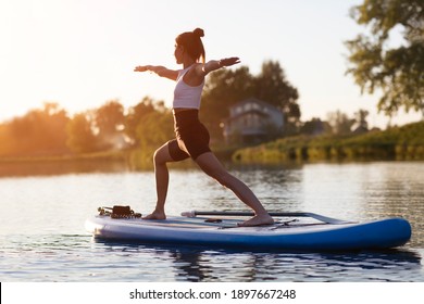 Woman Doing Yoga On Sup Board At Sunset. Outdoor Summer Activity. Sup Yoga.  Social Distancing. Copy Space. Mental Health