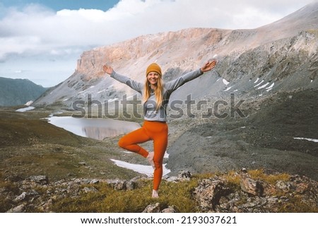 Woman doing yoga practice in mountains travel retreat healthy lifestyle active summer vacations trip outdoor mental health girl training tree pose balance asana 
