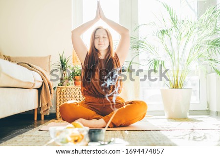 Woman doing yoga at sunny home.