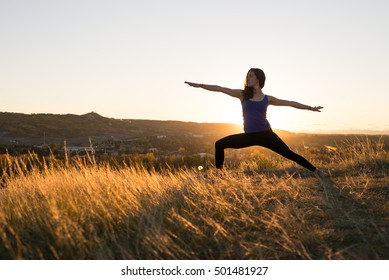 Woman Doing Yoga Warrior II Pose During Evening Sunset