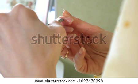 Woman doing yourself a manicure at home on the table. 4K