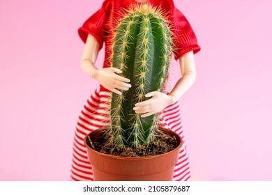 Woman Doll Hugs A Cactus Plant On Light Pink Background. Harmful, Painful And Toxic Relationship, Partner Problems, Emotional Abuse Concept