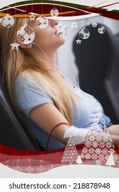 Woman Donating Blood And Listening To Music Device Against Christmas Frame