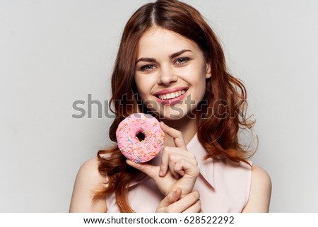Woman with donut, pink donut, woman smiling, donut in hands