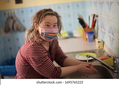 Woman With Down Syndrome With Respirator Mask In Kitchen