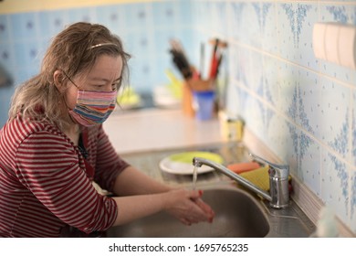 Woman With Down Syndrome With Respirator Mask In Kitchen