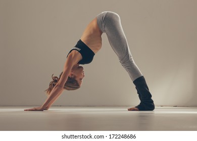 Woman In The Downward Facing Dog Yoga Pose.