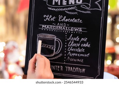 Woman drawing christmas menu of cocoa bar on small chalkboard. - Powered by Shutterstock