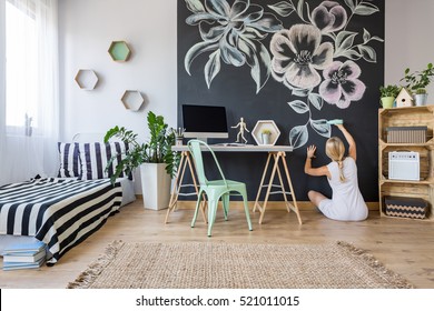 Woman Drawing Flowers On Chalkboard Wall In Multifunctional Home Interior