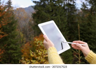 Woman drawing with graphic tablet in mountains on autumn day, closeup - Powered by Shutterstock