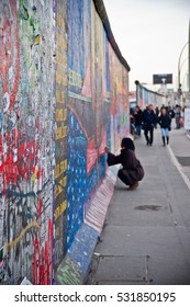 Woman Drawing On The Street Art Painted Berlin Wall