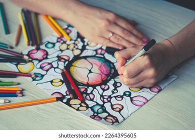 A woman draws neurographics  close  up  Abstract neurographic drawing and marker  colored pencils  neurographic concept  Mental health  adult fine motor skills  creativity  psychology 