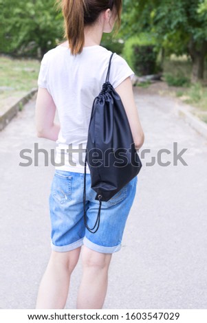 Woman with drawstring bag on the shoulder. Cropped.
