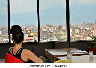 Woman With Dreadlocks Sitting In A Bar Watching Kathmandu City, Nepal