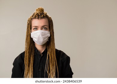 A woman with dreadlocks is wearing a face mask - Powered by Shutterstock