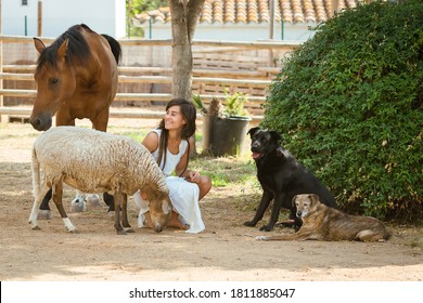 Woman with dreadlocks in white dress posing with her farm animals. - Powered by Shutterstock