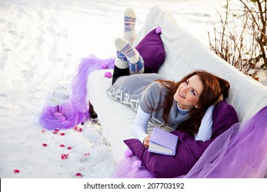 Woman dreaming at winter forest lying on the couch - Powered by Shutterstock