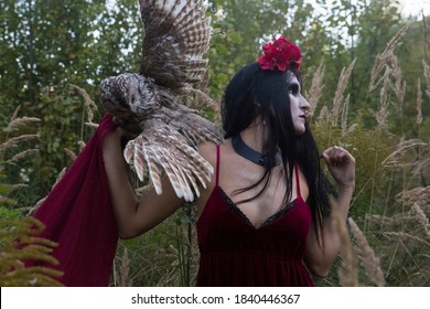 Woman In Dress And Make-up For Halloween In The Forest. On The Shoulder Of A Woman Is A Night Owl.