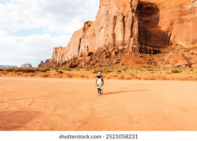 Woman in a dress walking toward Rain God Mesa in Monument Valley. - Powered by Shutterstock