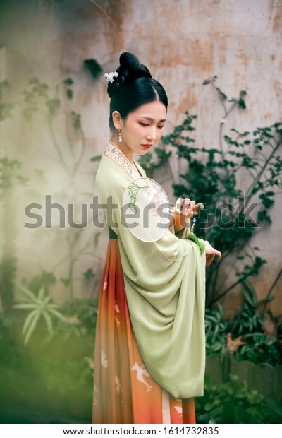 Woman dressed in Chinese ancient costumes like\
poetry and painting