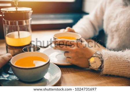 woman drink hot orange tea in cafe