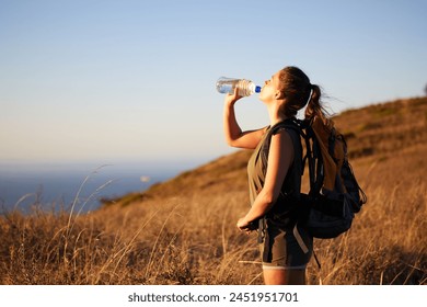 Woman, drink water and hiking outdoor for fitness or travel, thirst and hydration with exploring nature. Backpacking, adventure and trekking in New Zealand with h2o drink for nutrition and health - Powered by Shutterstock