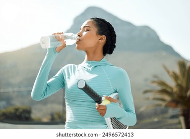 Woman, drink and water on court for tennis, exercise and playing game with racket, ball and bottle. Athlete, thirsty and ready for workout, training and club competition with hydration and resilience - Powered by Shutterstock