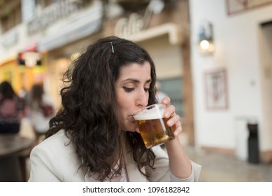 Woman drinking beer in bar terrace
