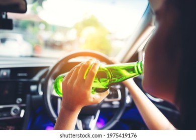 Woman Drinking From A Beer Bottle While Driving Car, A Concept Of Driving Intoxicated