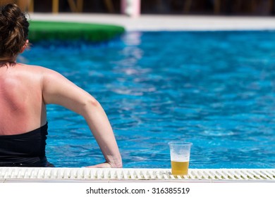 Woman Drinking Beer On The Swiming Pool