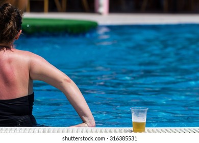 Woman Drinking Beer On The Swiming Pool