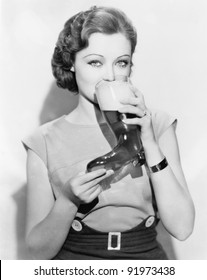 Woman drinking beer out of a boot shaped glass
