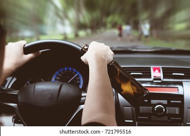 Woman drinking beer while driving a car