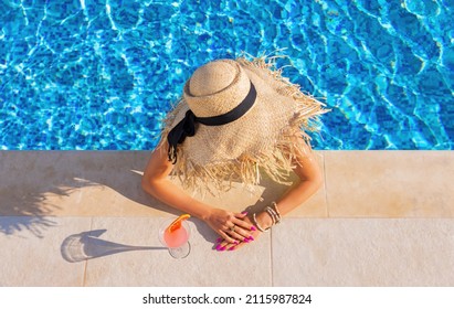 Woman drinking cocktail by the pool, view from above - Powered by Shutterstock