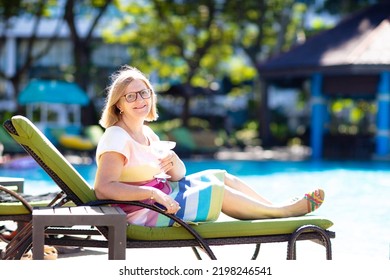 Woman Drinking Cocktail At Swimming Pool. Senior Lady With Exotic Drink In Luxury Beach Resort. Early Retirement. Active Retiree Travel The World.