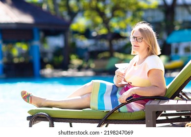 Woman Drinking Cocktail At Swimming Pool. Senior Lady With Exotic Drink In Luxury Beach Resort. Early Retirement. Active Retiree Travel The World.