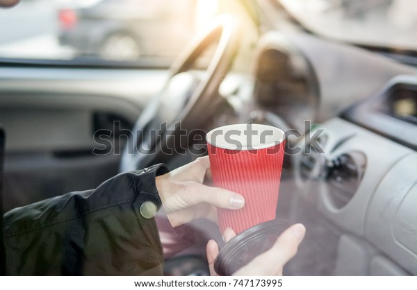 Woman drinking coffee in\
car